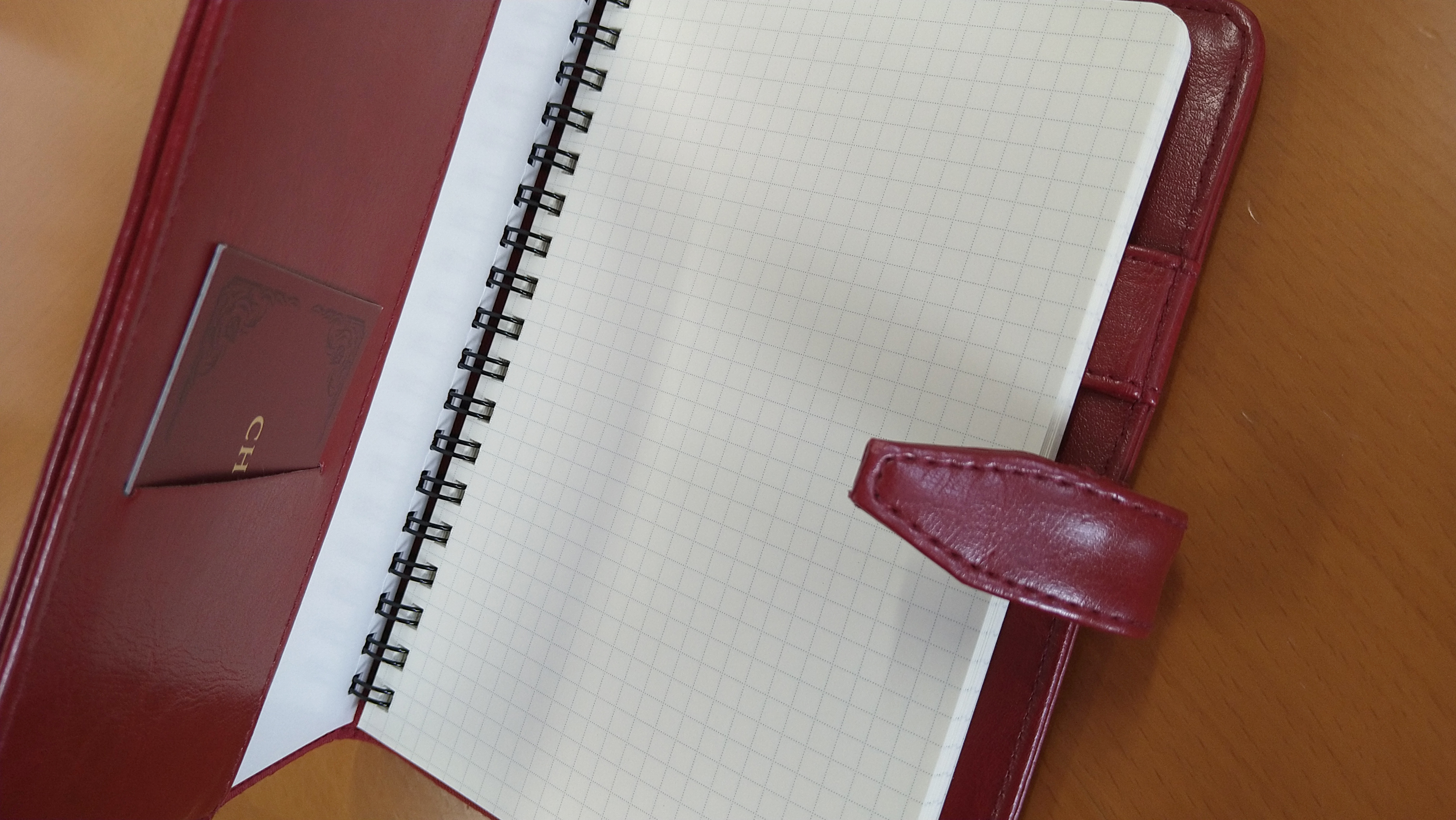 赤いレザー調ノートカバーに方眼紙のリングノートがセットされた状態